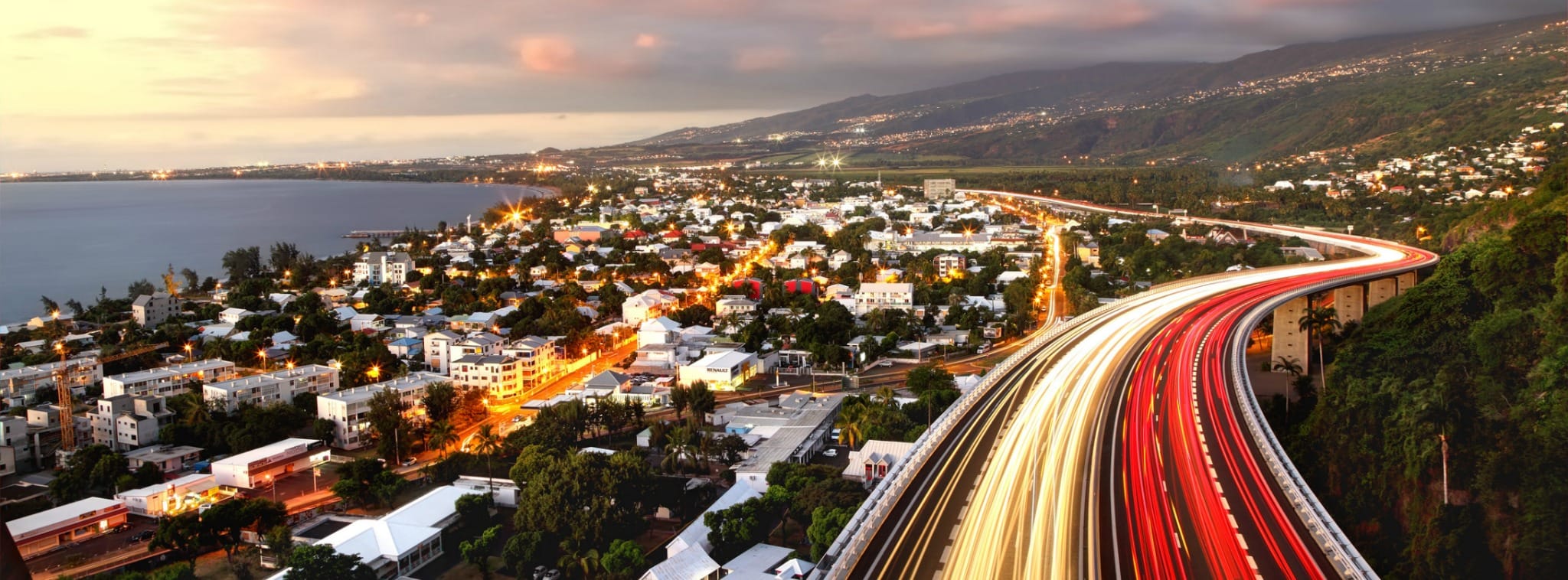 Vue panoramique d'une ville avec des routes éclairées, illustrant le développement du business sur l'île de La Réunion.