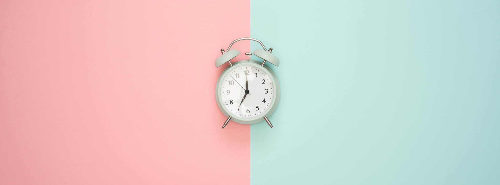 Réveil sur fond divisé en deux couleurs, représentant l'urgence et l'importance de se différencier de ses concurrents