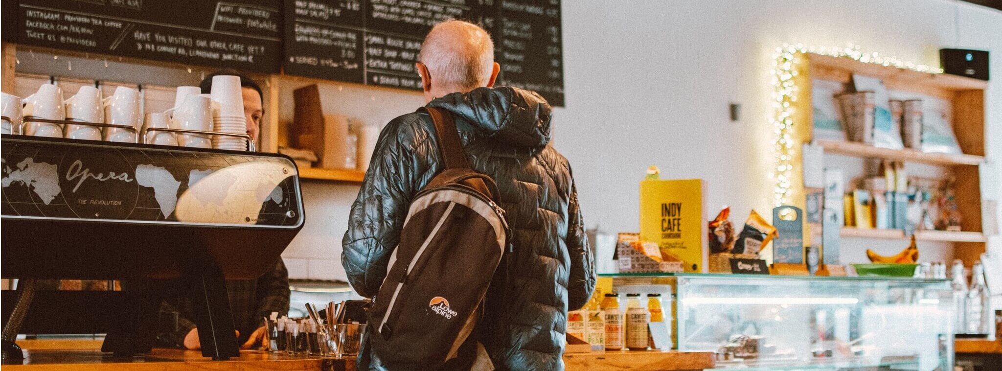 vendeur qui encaisse un client au comptoir du café