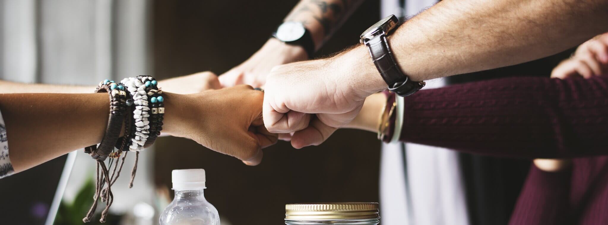 Équipe de vendeurs se tapant dans la main pour symboliser la cohésion et la motivation en boutique